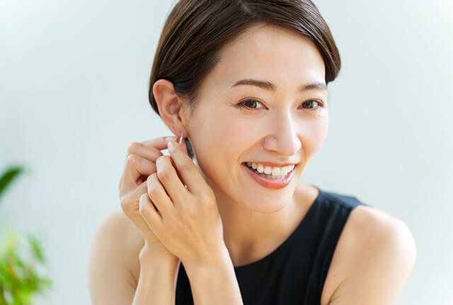 ピアスを付けようとしている女性