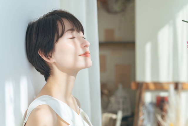 目を閉じて上を向く女性